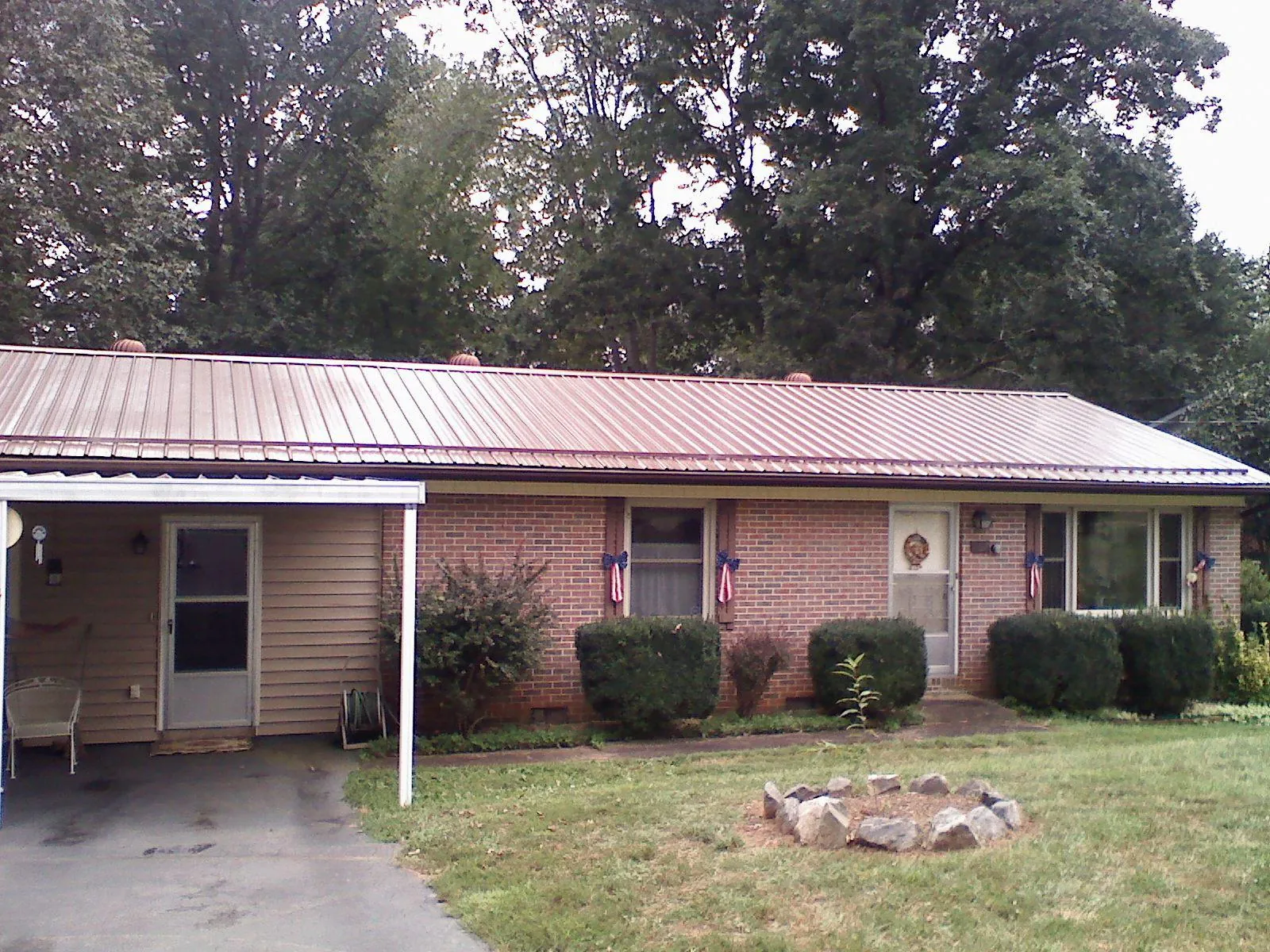 Bronze metal roof and carport on a brick ranch home in West Liberty